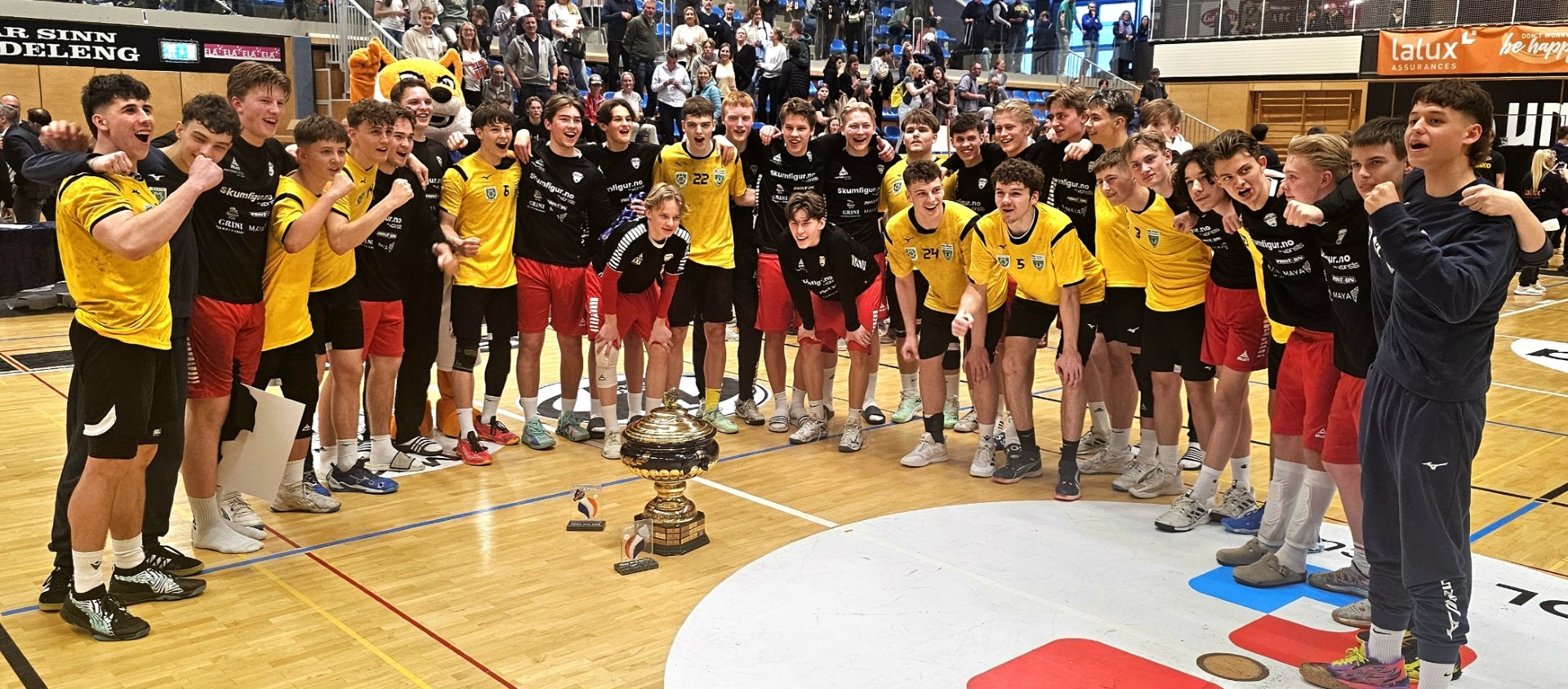 En rekke handballspillere med vinnerpokal i midten.